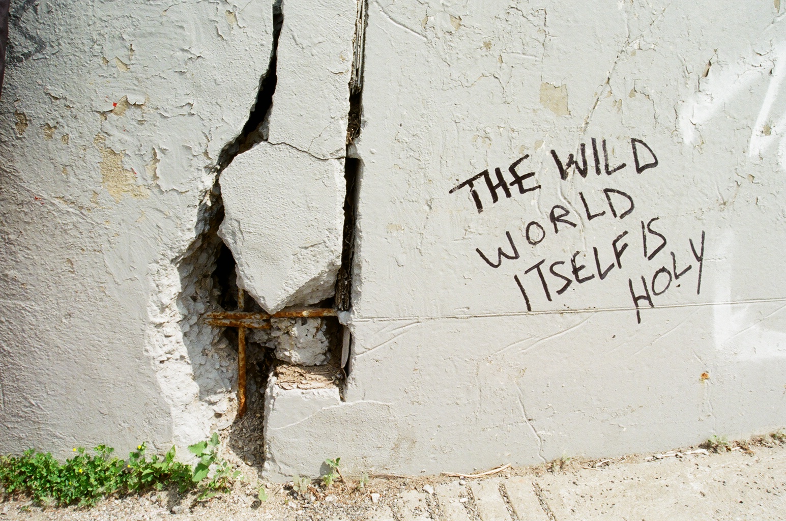 Image of uplifting graffiti, contrasted with a crumbling wall